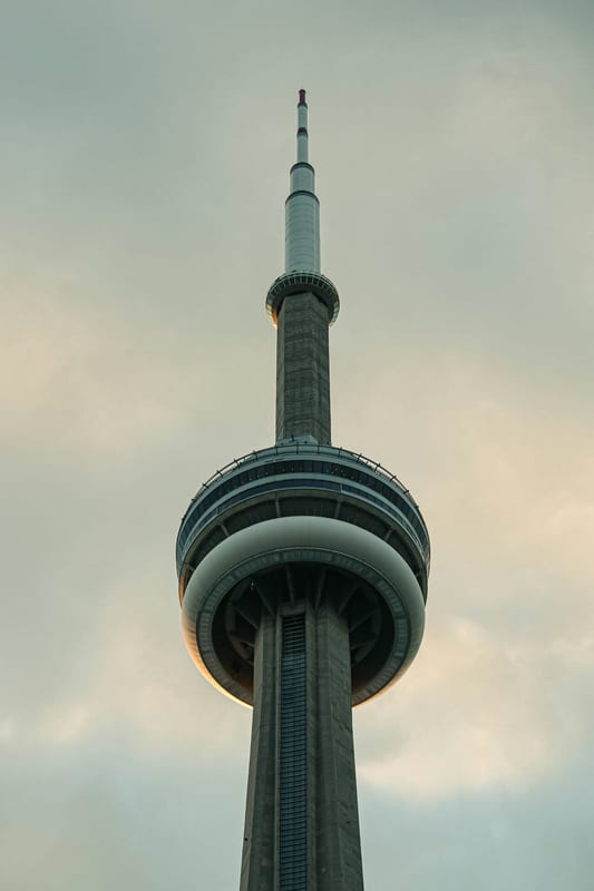 The top of the CN Tower against an overcast Toronto sky