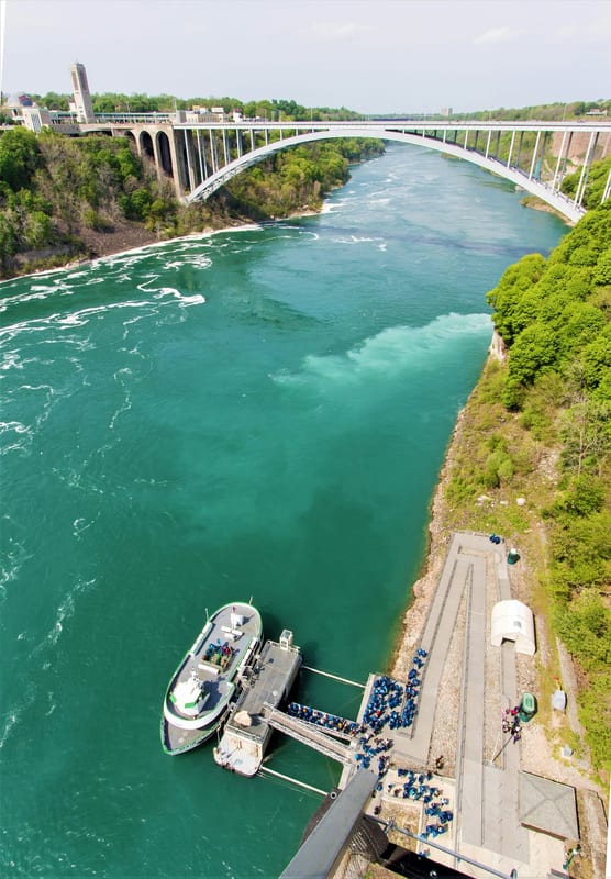 Aerial view of the Niagara River gorge, Rainbow Bridge, and a tour boat below