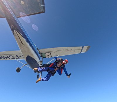 Skydivers leaving the plane into sunlit skies over Dundas, Ontario