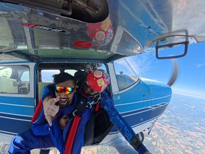 Grinning first-time tandem skydiver in the door before a jump near Toronto