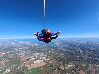 Tandem skydiver with Lake Ontario and the Niagara Escarpment laid out below near Toronto