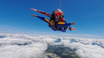 Tandem skydivers in freefall above the clouds near Toronto