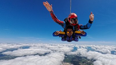 First-time tandem skydiver giving a thumbs-up in freefall over Ontario